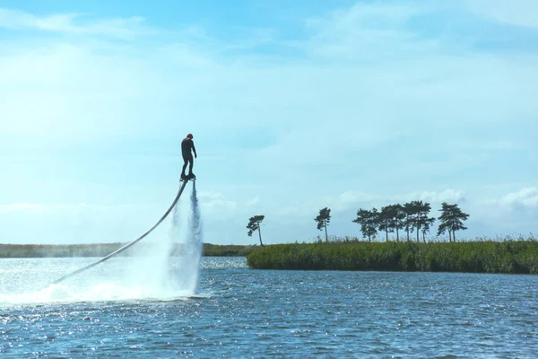 男に乗っている Flyboard 晴れた日にトーンダウン — ストック写真