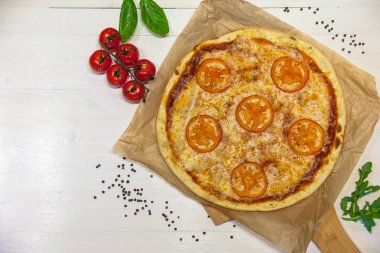 iştah açıcı pizza margarita malzemelerle düz beyaz bir tablo üzerinde yatıyordu
