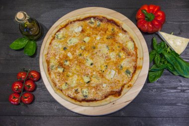 zeytinyağı ve fesleğen ile dört peynir ile iştah açıcı pizza bir siyah masaya düz yatıyordu bırakır
