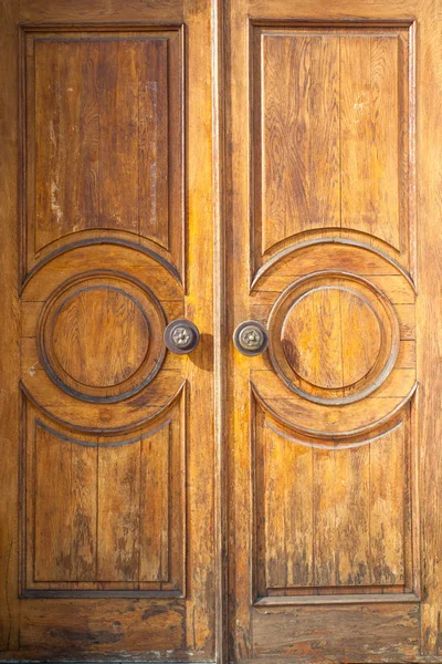 large solid wooden door with scuffs and cracks