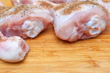 çiğ tavuk budu ile baharat bir kesme tahtası üzerinde yakın çekim