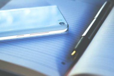 dolma kalem ve smartphone tonda bir defter üzerinde retro yalan