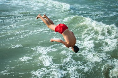 Genç adam suyun içine baş aşağı düşüyor