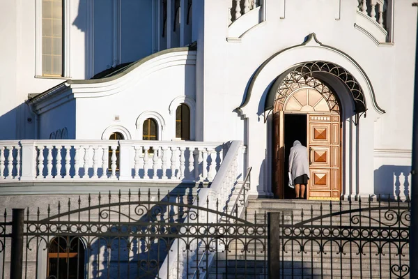 woman bows upon entering church