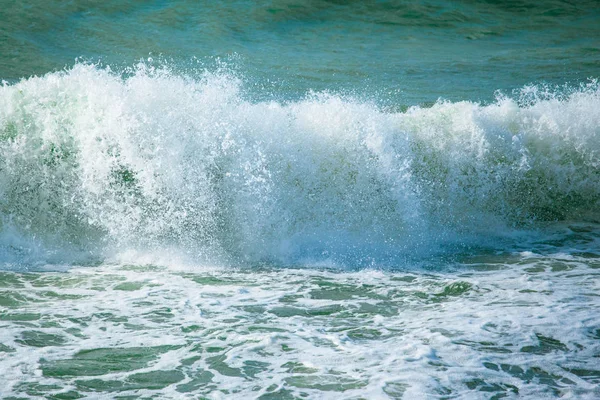 スプレーと白い泡とターコイズ ブルーの海の水の表面 — ストック写真