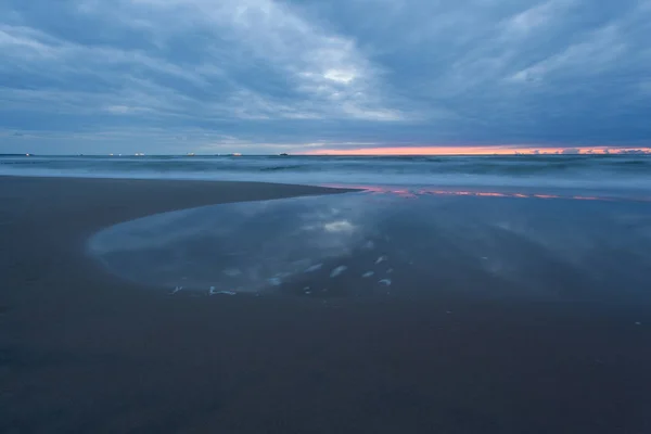 滑らかな海の表面と長時間露光の青い夕暮れの海岸 — ストック写真