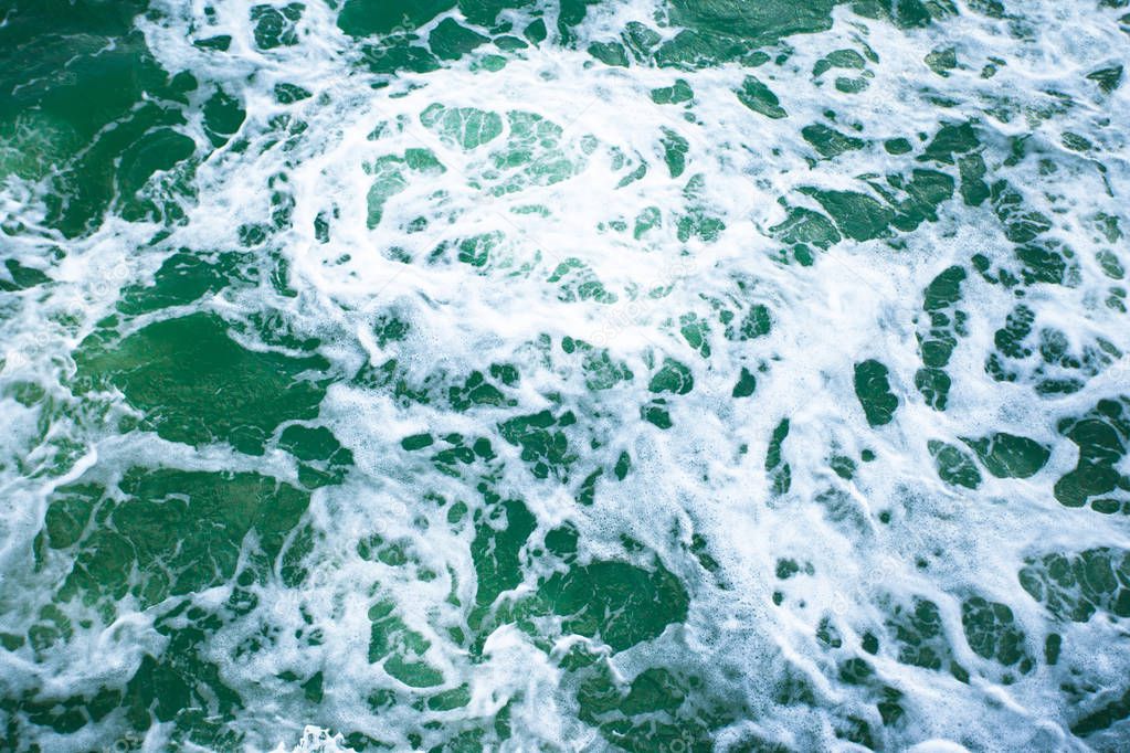 surface of turquoise ocean water with white foam, background, texture