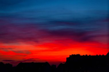 Şehir çatılar üzerinden parlak kırmızı günbatımı