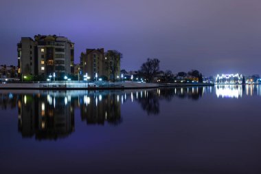 parlak ışıklar ile göl yakınında gece şehir manzarası