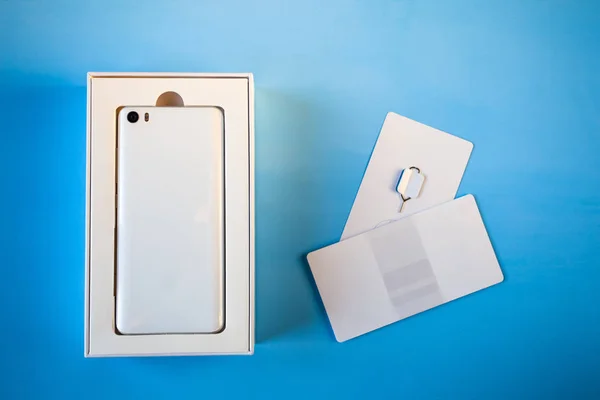 open box with new white smart phone