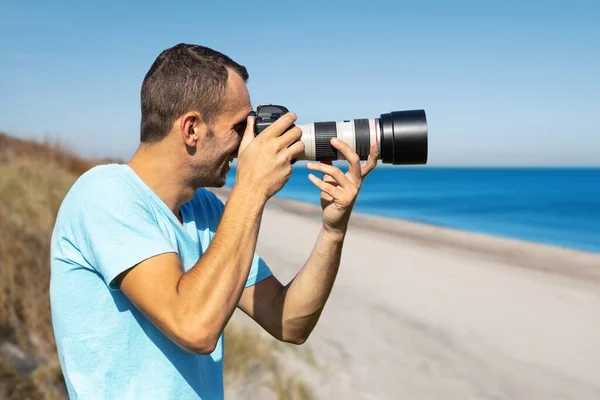 Młody Fotograf Dużym Profesjonalnym Aparatem Fotograficznym Tle Morza Plaży — Zdjęcie stockowe