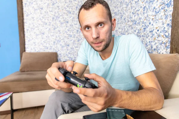 Oyun oynayan, elinde joystick olan genç bir kumarbaz.