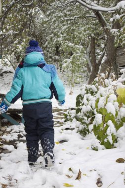 Karda yürüyen çocuk