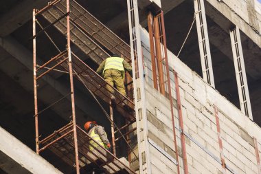 Sigortası olmayan bir yükseklikte korkusuz kaynakçı eseri. Kaynakçı iş yapım aşamasında binada bir yükseklikte.