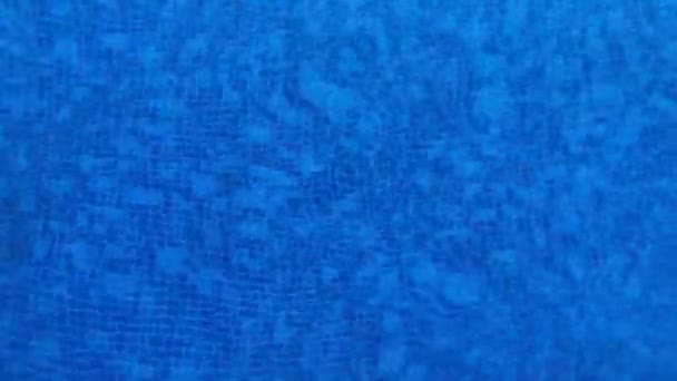Agua limpia y clara en la piscina. La vista desde arriba. El agua se mueve. El fondo de la piscina - pequeñas baldosas azules y azules . — Vídeos de Stock