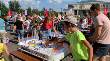 İnsanlar yaz caddesinde masa oyunları oynuyorlar.