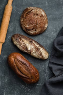 Koyu arka planda kırsal ekmek. Düz yatıyordu.