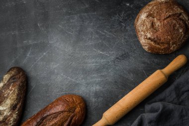 Koyu arka planda, fotokopi alanı olan köylü ekmeği. Düz yatıyordu. El yapımı..