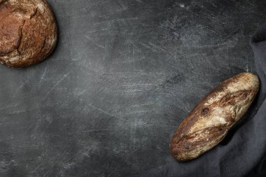 Koyu arka planda, fotokopi alanı olan köylü ekmeği. Düz yatıyordu. El yapımı..