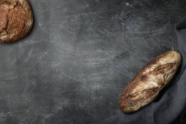 Koyu arka planda, fotokopi alanı olan köylü ekmeği. Düz yatıyordu. El yapımı..