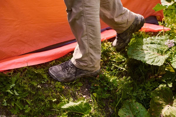 turistler bir çadır, bir kamp koydu. Adamın bacakları kirli turist Boots yanında çadır