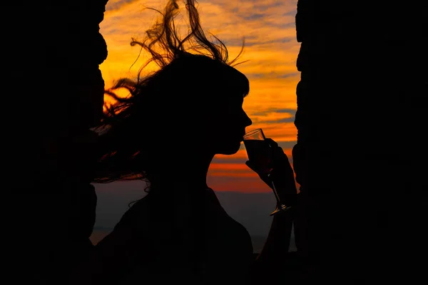 woman with flying hair at sunset