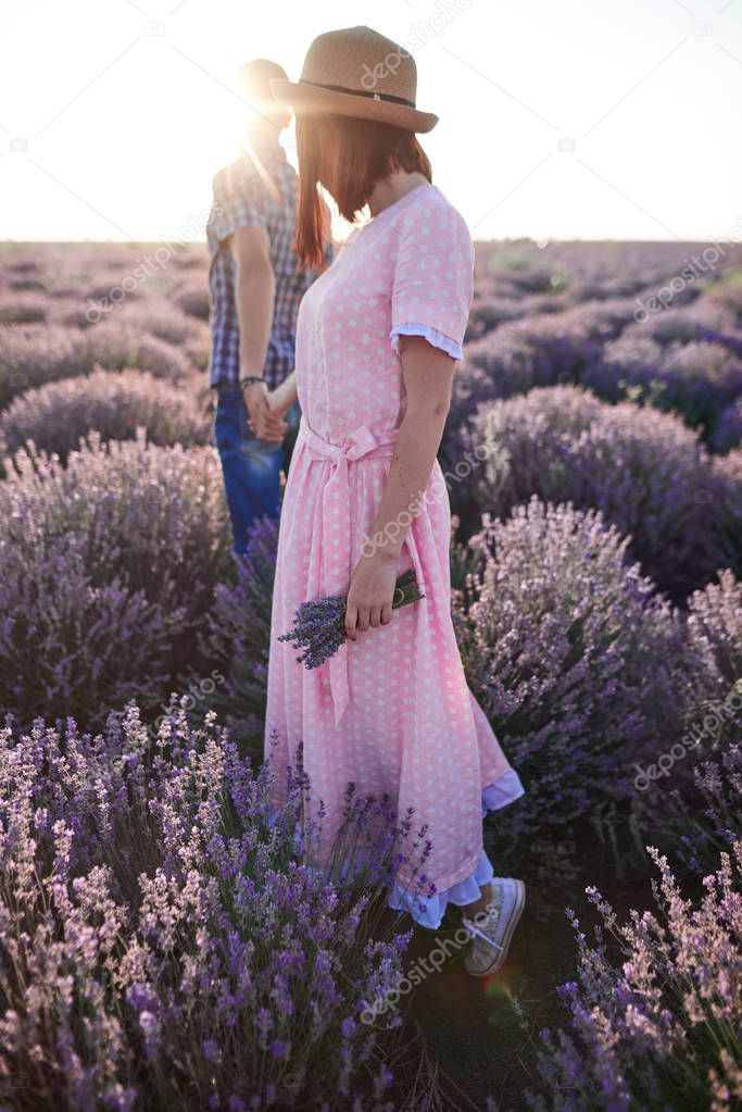 Young girl in the romantic dress and her man in the lavender fields