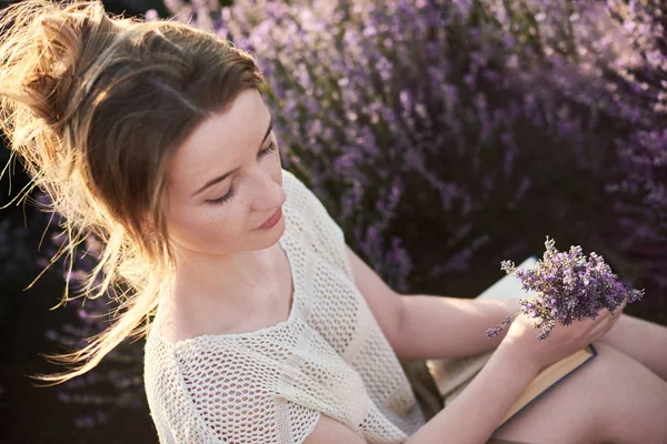 浪漫的女孩坐在草地和薰衣草花 看书和梦想 — 图库照片
