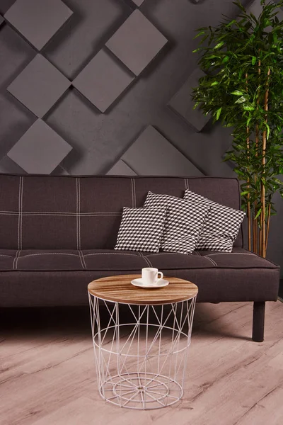 Minimalist ve lüks gri ev iç tasarım kanepe, açık kahverengi kahve masası ile bitki. Yazıt için boşluk Kopyala, poster sahte. Kahverengi ahşap parke