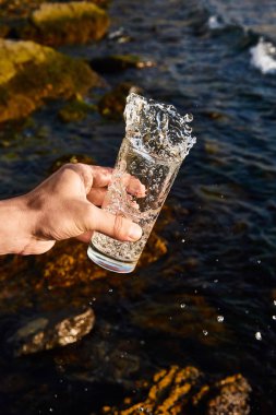 Büyük bardaktan şeffaf su sıçraması. Splash form yaratıcı reklam birleştirme kullanımı için farklı bir şekil