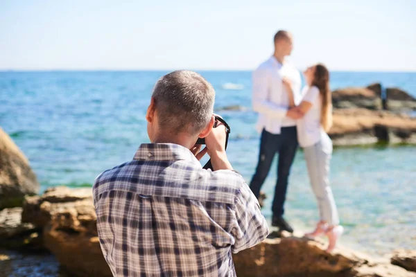 Fotógrafo trabajando con pareja en la playa, fotografía de boda profesional —  Fotos de Stock