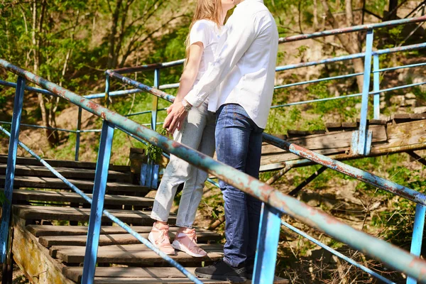 Mladý objímající pár na schodech v zeleném parku — Stock fotografie