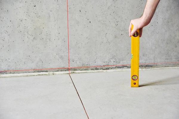 Homem com piso de verificação de nível de laser e paredes — Fotografia de Stock