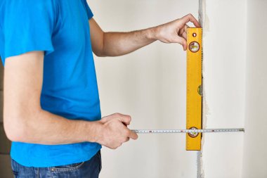 Mavi t-shirt erkekte duvar düzeyini denetler