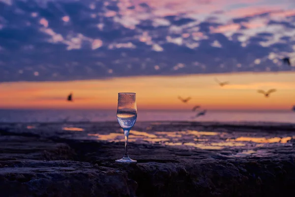 海边日出背景的一杯白葡萄酒 — 图库照片