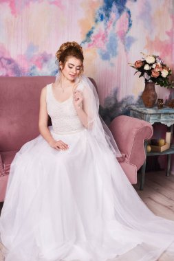 Genç ve güzel gelin düğün çekimi için hazırlanıyor.