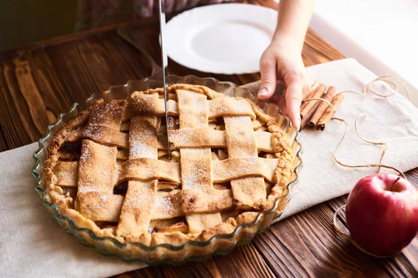 Femme coupant un dessert de tarte aux pommes fraîchement cuite sur la table en bois — Photo