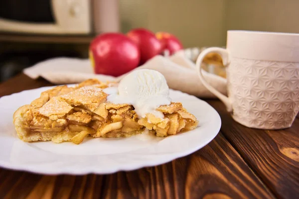 Leckerer hausgemachter Apfelkuchen, Scheibe mit Eis. Äpfel. Teller, Bettwäsche Handtuch Holz Hintergrund Tasse Tee — Stockfoto