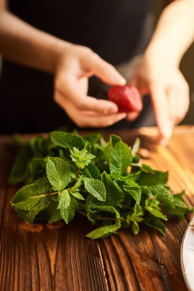 Gătit de răcire cocktail de vară cu căpșuni, gheață și mentă și în jurul boabelor sunt căpșuni proaspete coapte și var — Fotografie, imagine de stoc