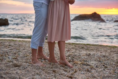 aşık çift ayakta ve okyanus kıyısında plajda gün doğumu toplantı