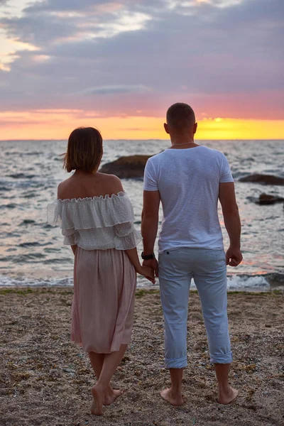 Pareja en el amor están de pie y encuentro amanecer en la playa en la orilla del océano —  Fotos de Stock