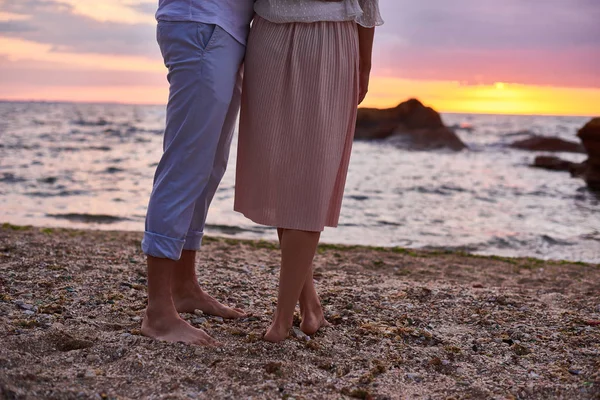 Влюбленная пара стоит и встречает восход солнца на пляже в океане — стоковое фото