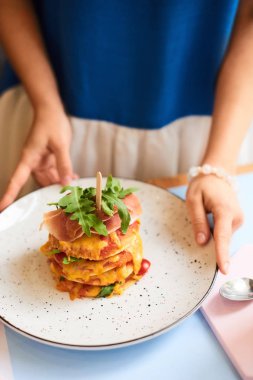 Sabah kahvesi. Bir kafede kahve fincanı ile kadınların ellerini yakın çekim. Bir kafede ahşap bir masa arka plan üzerinde latte fincan tutan kadın elleri, vintage renk tonu