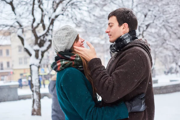 Jovem casal amoroso vestido com lenços xadrez caminhar na cidade velha no inverno — Fotografia de Stock