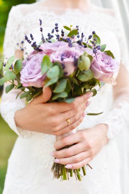 Ellere odaklan. Leylak tonları gül ve lavanta Rustik tarzı düğün buketi. çiçeklerve gelinin elleri yakın çekim