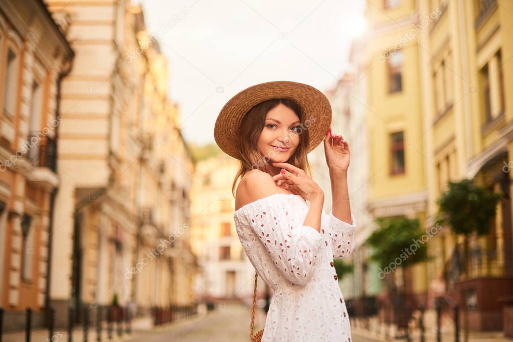 pretty woman with straw hat on head on resort, holiday, vacation trip in Europe in summer time.