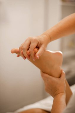 Kaplıca salonunda ayak masajı yapan bir masöz. Profesyonel ayak masajı.