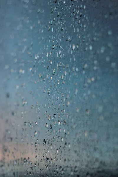 Vertical shot with raindrops on a window