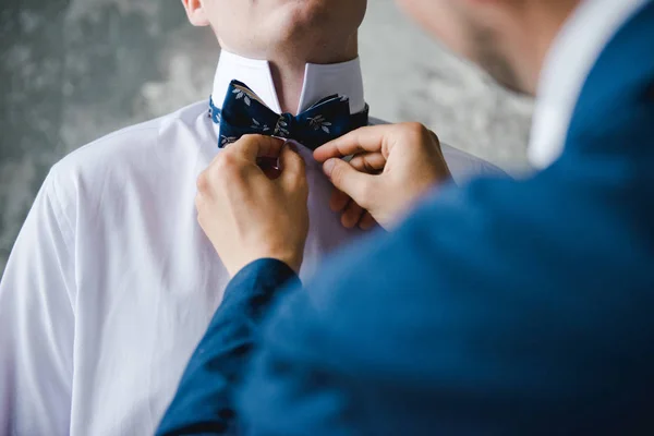 Morning of the groom. Groom morning preparation. Young and handsome groom getting dressed in a wedding shirt