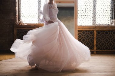 Gelin sabah aynanın yanında toplanıyor. Gelin sabah toplanıyor. Şık pembe gelinlik. Gelin aynaya yakın bir elbise içinde dönüyor..